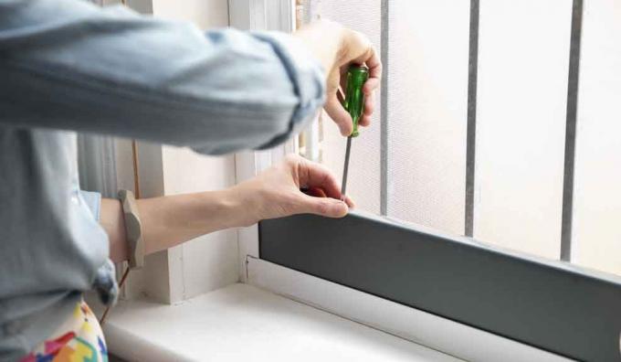 Avvitare o avvitare la piastra di tenuta del condizionatore d'aria portatile al telaio della finestra