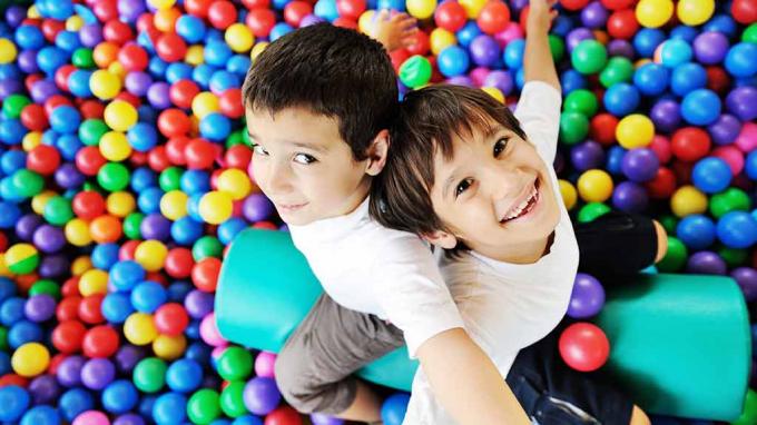 duas crianças no campo de bolinhas brincando de segurança