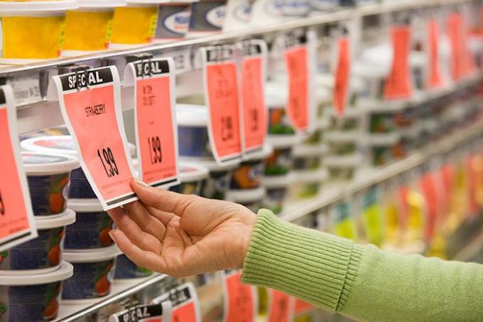 Comprador comprobando el precio unitario en la etiqueta del supermercado